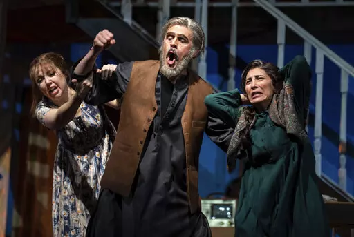 Maureen McKay, left, who portrays Laila, John Moore, who portrays Rasheed, and Karin Mushegain, who portrays Mariam, perform in a dress rehearsal for the opera "A Thousand Splendid Suns," in Seattle, on Wednesday, Feb. 22, 2023. Making its world debut Saturday, Feb. 25, 2023, it is based on a popular novel by Kabul-born author Khaled Hosseini that explores the inner worlds of Mariam and Laila over decades of Afghan history, some with stark parallels to the present. (AP Photo/Stephen Brashear)