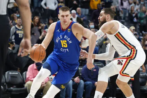 Denver Nuggets center Nikola Jokic, left, drives past New Orleans Pelicans center Jonas Valanciunas in the first half of an NBA basketball game Friday, Feb. 4, 2022. (AP Photo/David Zalubowski)