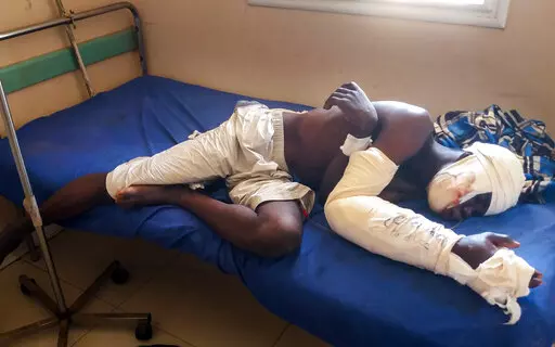Saga Saganla, 30, from Diawely, lies on his bed at Somine Dolo hospital in Mopti, Mali, Friday June 24, 2022. Saganla survived an attack by nearly 100 jihadis on motorbikes who had gathered in his village in central Mali Sunday June 19. At least 132 people were killed in several villages in the Bankass area of central Mali during the attack on Saturday and Sunday, according to the government which blames the Group to Support Islam and Muslims jihadi rebels linked to al-Qaida.(AP Photo/ Hamidou S