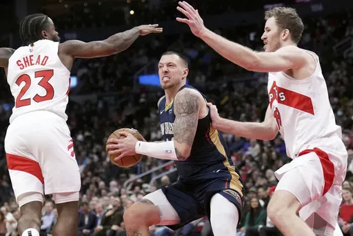 New Orleans Pelicans center Daniel Theis (10) looks for a move between Toronto Raptors guard Jamal Shead (23) and Jakob Poeltl (19) during the first half of an NBA basketball game in Toronto on Monday, Jan. 27, 2025. (Nathan Denette/The Canadian Press via AP)
