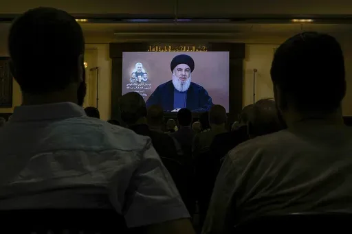 Hezbollah supporters watch a speech given by Hezbollah leader Sayyed Hassan Nasrallah on a screen during a ceremony to commemorate the death of senior Hezbollah commander Taleb Sami Abdullah, 55, who was killed last week by an Israeli strike in south Lebanon, in the southern Beirut suburb of Dahiyeh, Lebanon, Wednesday, June 19, 2024. (AP Photo/Bilal Hussein)