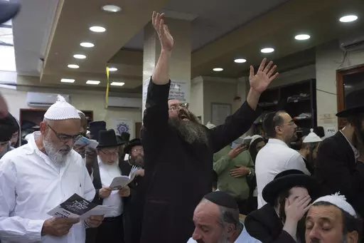 Orthodox Jews pray at the tomb of Rabbi Nachman, the great grandson of the founder of Hasidic movement, in the town of Uman, 200 kilometers (125 miles) south of Ukraine's capital Kiev, Ukraine, Sunday, Sept. 25, 2022. Thousands of Hasidic Jewish pilgrims flocked to central Ukraine to mark the Jewish new year Sunday, ignoring international travel warnings as Russia struck more targets from the air and mobilized its citizens to stem losses in the war that has entered its eighth month. (AP Photo/Ef