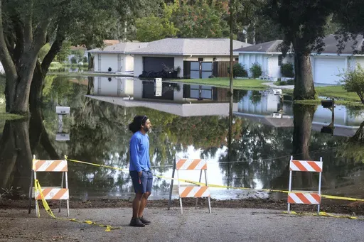 A Spring Oaks resident checks out the rising floodwaters from the Little Wekiva River on Spring Oaks Blvd. in his neighborhood in Altamonte Springs, Fla., Friday, Oct. 11, 2024. Central Florida rivers are forecast to crest in the coming days because of the excessive rainfall from Hurricane Milton. (Joe Burbank/Orlando Sentinel via AP)