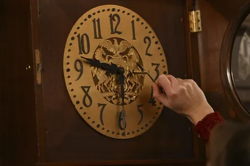 Bethany Gill winds a clock in the Pennsylvania Supreme Court chamber, Dec. 13, 2024, in Harrisburg, Pa. It's one of 273 clocks in Pennsylvania's ornate state Capitol complex buildings that must be wound by hand. (AP Photo/Marc Levy)