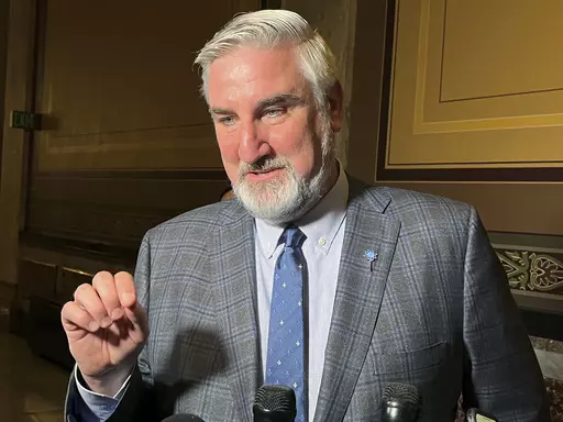 Indiana Gov. Eric Holcomb speaks with reporters at the Indiana Statehouse on Tuesday, April 4, 2023, in Indianapolis. Holcomb did not commit on Tuesday to signing a bill approved last week by Republican legislators that would ban virtually all gender-affirming medical care for those younger than 18 in the state. Holcomb faces a Wednesday deadline to sign or veto the proposal. (AP Photo/Tom Davies)