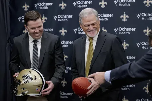 New Orlean Saints new coach Kellen Moore Kellen Moore, left, and Saints general manager Mickey Loomis, right, smile during an NFL football press conference in Metairie, La. Thursday, Feb. 13, 2025. (AP Photo/Matthew Hinton)