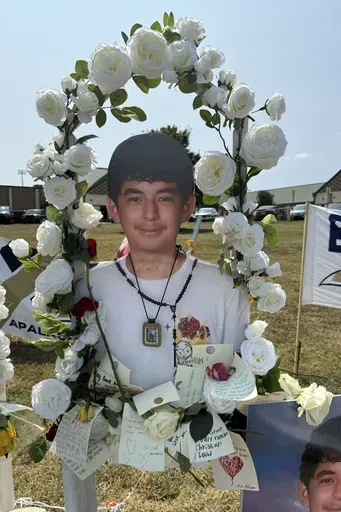 A poster with an image of shooting victim Christian Angulo is displayed at a memorial outside Apalachee High School, Tuesday, Sept. 10, 2024, in Winder, Ga. (AP Photo/Charlotte Kramon)