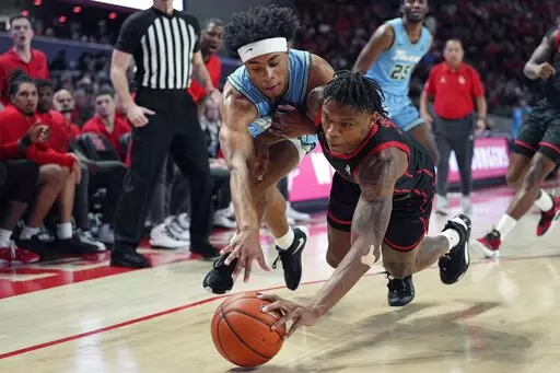Tulane guard Jalen Cook and Houston guard Marcus Sasser dive after a loose ball during the first half of an NCAA college basketball game, Wednesday, Feb. 22, 2023, in Houston. (AP Photo/Kevin M. Cox)