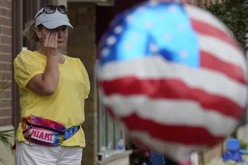 A woman wipes away tears after a mass shooting at an Independence Day parade that left seven people dead and dozens wounded, in the Chicago suburb Highland Park, July 4, 2022. Violence and mass shootings often surge in the summer months, especially around the Fourth of July, historically one of the deadliest days each year. (AP Photo/Nam Y. Huh, File)