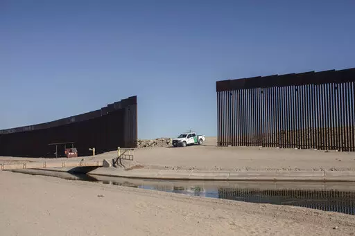A Customs and Border Protection vehicle waits for a group of Nicaraguan migrants as they walk towards the US border to turn themselves in and ask for asylum, from Algodones, Mexico, Dec. 2, 2021. The Biden administration released a plan Tuesday to deal with an increase in already historic numbers of migrants at the U.S.-Mexico border with the lifting of a public health order that has kept people from seeking asylum — and that Republican and some Democratic lawmakers say should be kept in place