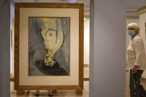 Amadeo Modigliani's 1908 "Nude with a Hat," is hung upside down because another painting by him, "Maud Abrantes," on the reverse side of the same canvas is oriented correctly, while on display at Haifa University's Hecht Museum in Haifa, Israel, June 28, 2022. Curators at the museum using x-ray technology have discovered three previously unknown sketches by the celebrated 20th century artist hiding beneath the surface of the painting. (AP Photo/Ariel Schalit)