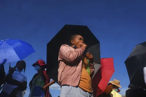Vekile Sesha waits in line outside a garment factory in Maseru, Lesotho Monday, Feb. 28, 2022. Sesha lost her job when the coronavirus pandemic hit the world two years ago and the global fashion industry crumple. when, faced with collapsing demand, brands canceled orders worth billions of dollars and few felt the effects so harshly as the tens of millions of workers, most of them women, who stitched the world's clothes. (AP Photo/Neo Ntsoma)