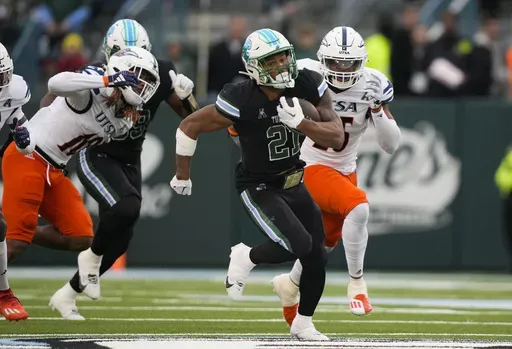 Tulane running back Makhi Hughes (21) carries past UTSA linebackers Martavius French (10) and Avery Morris on a 58-yard run in the first half of an NCAA college football game in New Orleans, Friday, Nov. 24, 2023. (AP Photo/Gerald Herbert, File)