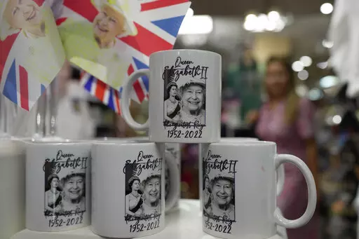 Mugs with print of Queen Elizabeth II are displayed for sale at a gift shop in London, Monday, Sept. 12, 2022. Just days after the death of Queen Elizabeth II, unofficial souvenirs have rolled out at royal-themed gift shops in London and online marketplaces like Amazon and Etsy. (AP Photo/Kin Cheung)