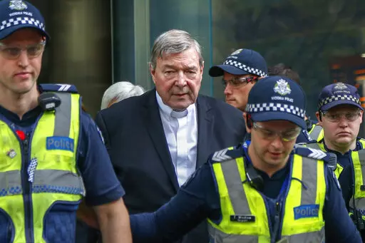 Cardinal George Pell, center, the most senior Catholic cleric to face sex charges, leaves court in Melbourne, Australia, May 2, 2018. Pell, who was the most senior Catholic cleric to be convicted of child sex abuse before his convictions were later overturned, has died Tuesday, Jan. 10, 2023, in Rome at age 81. (AP Photo/Asanka Brendon Ratnayake, File)