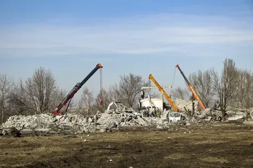 Workers clean rubbles after Ukrainian rocket strike in Makiivka, in Russian-controlled Donetsk region, eastern Ukraine, Tuesday, Jan. 3, 2023. Russia's defense ministry says 63 of its soldiers have been killed by a Ukrainian strike on a facility in the eastern Donetsk region where military personnel were stationed. (AP Photo)