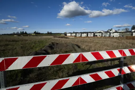 Homes are seen on Thursday, Feb. 22, 2024, in the southwest Portland, Ore., suburb of Beaverton. The so-called urban growth boundary, established by a 1973 law that placed boundaries around cities to prevent urban sprawl and preserve nature and farmland, is seen in the background along SW Tile Flat Road. (AP Photo/Jenny Kane)