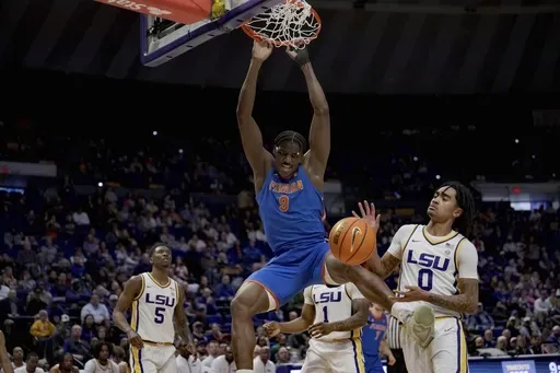 Florida center Rueben Chinyelu (9) dunks against LSU guard Vyctorius Miller (0) during the first half of an NCAA college basketball game in Baton Rouge, La., Saturday, Feb. 22, 2025. (AP Photo/Matthew Hinton)