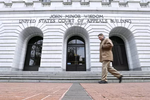 A man walks in front of the 5th U.S. Circuit Court of Appeals, Jan. 7, 2015, in New Orleans. A Louisiana lawyer who objected to the state bar association’s public statements on a variety of issues, from simple health tips to LGBTQ rights, can no longer be forced to join or pay dues to the association, the 5th U.S. Circuit Court of Appeals ruled Monday, Nov. 13, 2023. (AP Photo/Jonathan Bachman, File)