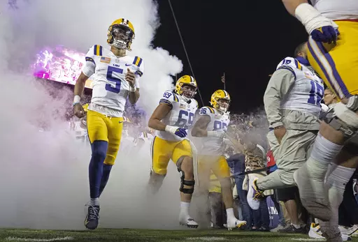 LSU quarterback Jayden Daniels (5) takes the field with offensive lineman Charles Turner III (69) and tight end Mason Taylor (86) before the kickoff of an NCAA college football game against Florida, Saturday, Nov. 11, 2023, in Baton Rouge, La. ( Hilary Scheinuk/The Advocate via AP)