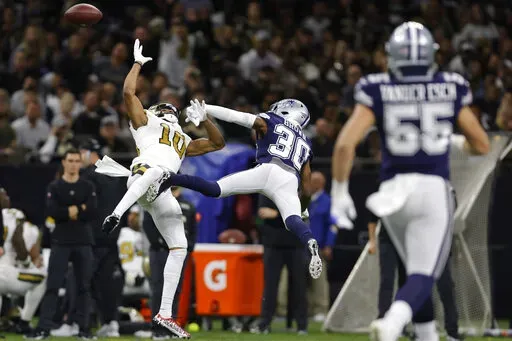 Dallas Cowboys cornerback Anthony Brown (30) defends against a pass to New Orleans Saints wide receiver Tre'Quan Smith (10) during the first half of an NFL football game, Thursday, Dec. 2, 2021, in New Orleans. (AP Photo/Brett Duke)