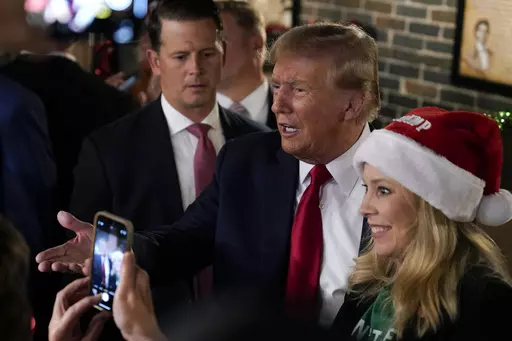Former President Donald Trump greets supporters during a stop at the Front Street Pub & Eatery, Tuesday, Dec. 5, 2023, in Davenport, Iowa. (AP Photo/Charlie Neibergall)