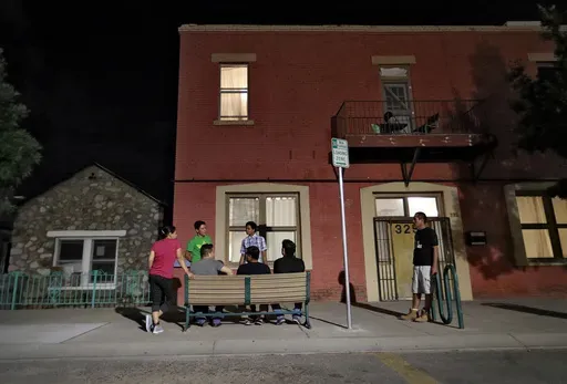 Migrant parents socialize outside the Annunciation House, June 26, 2018, in El Paso, Texas. A Texas judge ruled against the state attorney general on Tuesday, July 2, 2024, in his effort to shut down a migrant shelter in El Paso that he claimed encourages illegal migration. (AP Photo/Matt York, File)