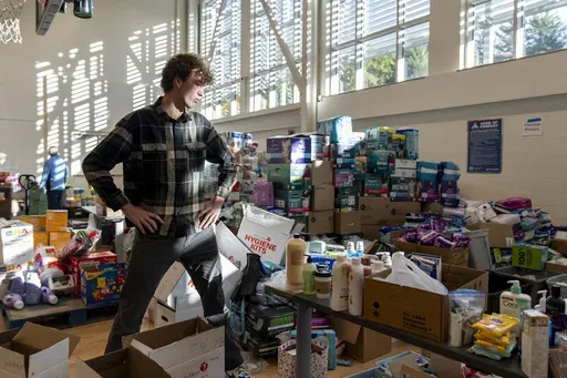 High school senior Nathan Flaherty pauses while packing hygiene kits for people in need of supplies as he volunteers in the aftermath of Hurricane Helene, Wednesday, Oct. 16, 2024, at the Dr. Wesley Grant Sr. Southside Community Center in Asheville, N.C. (AP Photo/Stephanie Scarbrough)