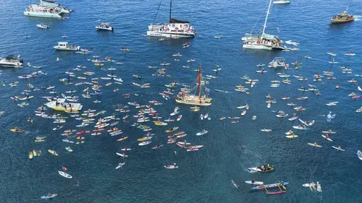 The community gathers in the waters of Hanakaoʻo Park during a paddle out ceremony on the one-year anniversary of the Lahaina wildfire on Thursday, Aug. 8, 2024, in Lahaina, Hawaii. (AP Photo/Mengshin Lin)