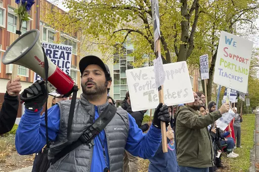 Teachers and their supporters hold signs, chant and rally the crowd with bullhorns on the first day of a teacher's strike in Portland, Ore., on Nov. 1, 2023. Portland Public Schools said late Sunday, Nov. 26, it had reached a tentative deal with the teachers’ union that will send the district’s roughly 45,000 students back to class Monday after nearly a month without classes. (AP Photo/Claire Rush, File)