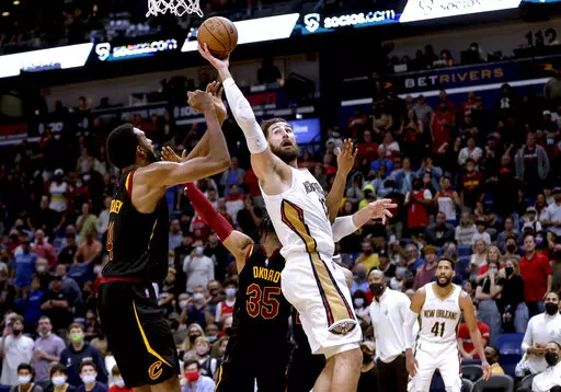 New Orleans Pelicans center Jonas Valanciunas (17) is fouled by Cleveland Cavaliers forward Isaac Okoro (35) while shooting over center Evan Mobley (4) during the fourth quarter of an NBA basketball game in New Orleans, Tuesday, Dec. 28, 2021. (AP Photo/Derick Hingle)