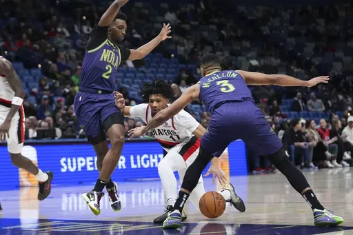 Portland Trail Blazers guard Shaedon Sharpe (17) drives to the basket between New Orleans Pelicans forward Herbert Jones (2) and guard CJ McCollum (3) in the first half of an NBA basketball game in New Orleans, Wednesday, Jan. 8, 2025. (AP Photo/Gerald Herbert)