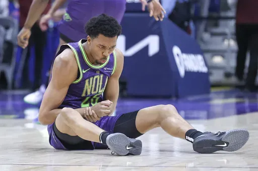 New Orleans Pelicans guard Trey Murphy III (25) holds his wrist after taking a fall on the court during the first quarter of an NBA basketball game against the Detroit Pistons in New Orleans, Monday, March 17, 2025. (AP Photo/Peter Forest)