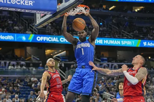 Orlando Magic forward Jonathan Isaac (1) dunks over New Orleans Pelicans guard Brandon Boston Jr. (11) and center Daniel Theis, right, during the first half of an NBA basketball game, Friday, Nov. 8, 2024, in Orlando, Fla. (AP Photo/John Raoux)