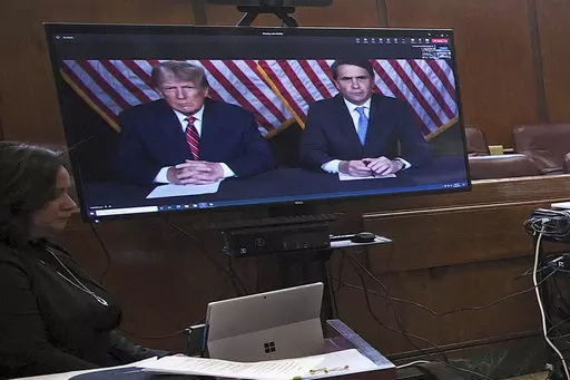 Former President Donald Trump, left on screen, and his attorney, Todd Blanche, right on screen, appear by video before a hearing begins in Manhattan criminal court, in New York, May 23, 2023. Trump speaks about his legal woes in a way that would make most defense attorneys wince. The former president has never hesitated to offer his opinion or joust with his antagonists. But legal experts say Trump's freewheeling speaking style could give prosecutors additional ammunition to use against him in c