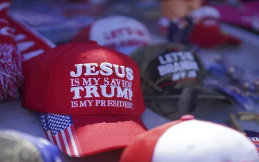 Hats reading a variety of slogans including, "Jesus is my savior, Trump is my president," are sold at a campaign rally for former President Donald Trump in Vandalia, Ohio, March 16, 2024. (AP Photo/Jessie Wardarski, File)