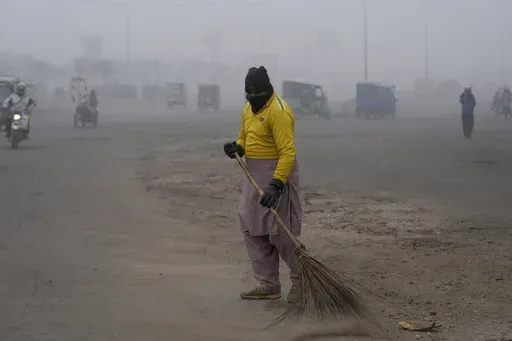 A sweeper cleans as smog envelops the area and reduces visibility in Lahore, Pakistan, Jan. 11, 2024. (AP Photo/K.M. Chaudary, File)