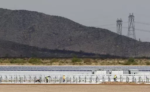 Workers continue to build rows of solar panels at a Mesquite Solar 1 facility under construction in Arlington, Ariz., Sept. 30, 2011. One of President Joe Biden's signature laws aimed to invigorate renewable energy manufacturing in the U.S. It will also helped a solar panel company reap billions of dollars. Arizona-based First Solar is one of the biggest early winners from the Democrats' Inflation Reduction Act, offering a textbook case of how the inside influence game works in Washington.(AP Ph