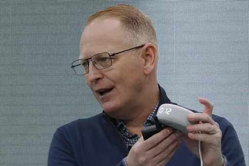 Dave Limp, senior vice president for Amazon devices & services, holds an Echo Dot with Clock device as he speaks Sept. 25, 2019, in Seattle. Amazon and telemedicine provider Teladoc Health are starting a voice-activated virtual care program that lets customers get medical help without picking up their phones. The service, for health issues that aren’t emergencies, will be available on Amazon’s Echo devices. Customers can tell the voice assistant Alexa that they want to talk to a doctor, and 