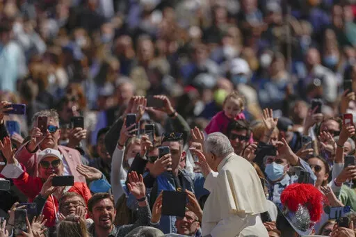Pope Francis on his popemobile drives through the crowd of faithful at the end of the Catholic Easter Sunday mass he led in St. Peter's Square at the Vatican, Sunday, April 17, 2022. For many Christians, this weekend marks the first time in three years they will gather in person to celebrate Easter Sunday. (AP Photo/Alessandra Tarantino)