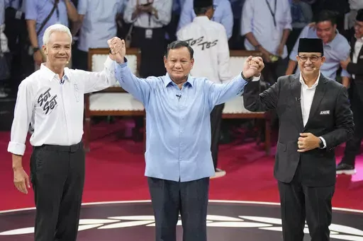 Presidential candidates, from left, Ganjar Pranowo, Prabowo Subianto and Anies Baswedan holds hands as they pose for photographers after the first presidential candidates' debate in Jakarta, Indonesia, Tuesday, Dec. 12, 2023. Indonesia, the world's third-largest democracy, will open its polls on Wednesday to nearly 205 million eligible voters in presidential and legislative elections, the fifth since Southeast Asia's largest economy began democratic reforms in 1998. (AP Photo/Tatan Syuflana, Fil