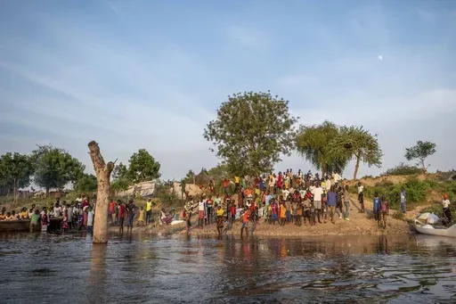 People gather along a flooded area in Jonglei state, South Sudan, Wednesday, Nov. 13, 2024. (AP Photo/Florence Miettaux)