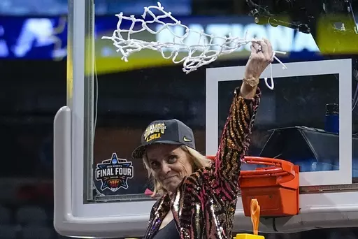 LSU head coach Kim Mulkey celebrates after cutting down the net after the NCAA Women's Final Four championship basketball game against Iowa, Sunday, April 2, 2023, in Dallas. Mulkey has agreed to a new 10-year contract worth about $32 million that will make her the highest-paid coach in women's college basketball, according to a person with knowledge of the deal.(AP Photo/Tony Gutierrez, File)