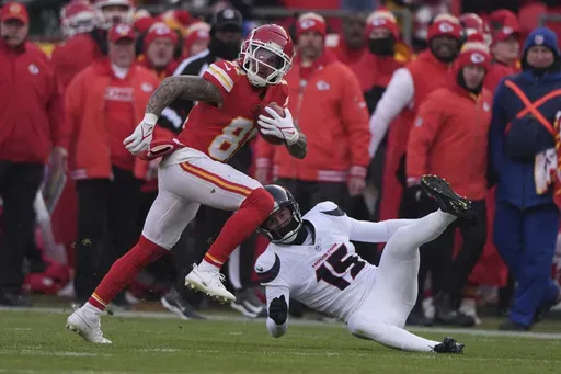 Kansas City Chiefs' Nikko Remigio, left, runs the opening kickoff past Houston Texans' Ka'imi Fairbairn (15) during the first half of an NFL football AFC divisional playoff game Saturday, Jan. 18, 2025, in Kansas City, Mo. (AP Photo/Charlie Riedel)