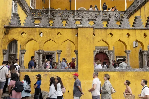 Tourists queue to visit the interior of the 19th century Pena Palace in Sintra, Portugal, Wednesday, Aug. 14, 2024. (AP Photo/Ana Brigida)