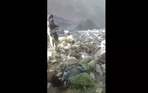 In this frame grab from video that was likely taken by the Taliban and posted online and provided by Afghan Witness, a UK-based open-source nonprofit, a Taliban fighter stands amid bodies on the ground, in the Dara district, of Panjshir province, Afghanistan, Sept. 14, 2022. The Taliban captured, bound and shot to death 27 men in Afghanistan’s Panjshir Valley last month during an offensive against resistance fighters in the area, according to a new report by Afghan Witness published Tuesday, O