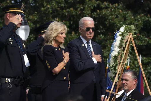 President Joe Biden and first lady Jill Biden put their right hand over their heart after placing flowers on a wreath during a ceremony honoring fallen law enforcement officers at the 40th annual National Peace Officers' Memorial Service at the U.S. Capitol in Washington, Oct. 16, 2021. Saluting on the left is James Smallwood, National Treasurer of the National Fraternal Order of Police. (AP Photo/Manuel Balce Ceneta, File)