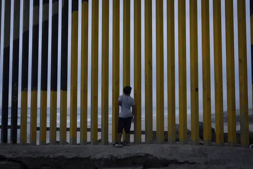 A boy looks through a border wall separating Mexico from the United States, Nov. 26, 2024, in Tijuana, Mexico. (AP Photo/Gregory Bull, File)