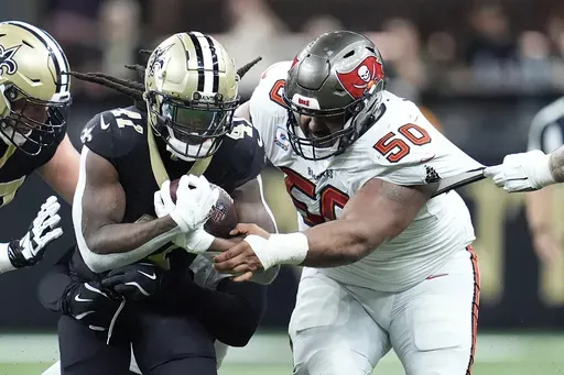 New Orleans Saints running back Alvin Kamara, left, runs against Tampa Bay Buccaneers defensive tackle Vita Vea (50) during the first half of an NFL football game in New Orleans, Sunday, Oct. 13, 2024. (AP Photo/Michael Conroy)