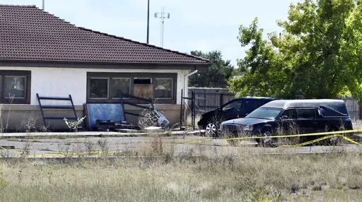 A hearse and debris sit behind the Return to Nature Funeral Home in Penrose, Colo., on Oct. 5, 2023. (Jerilee Bennett/The Gazette via AP, File)